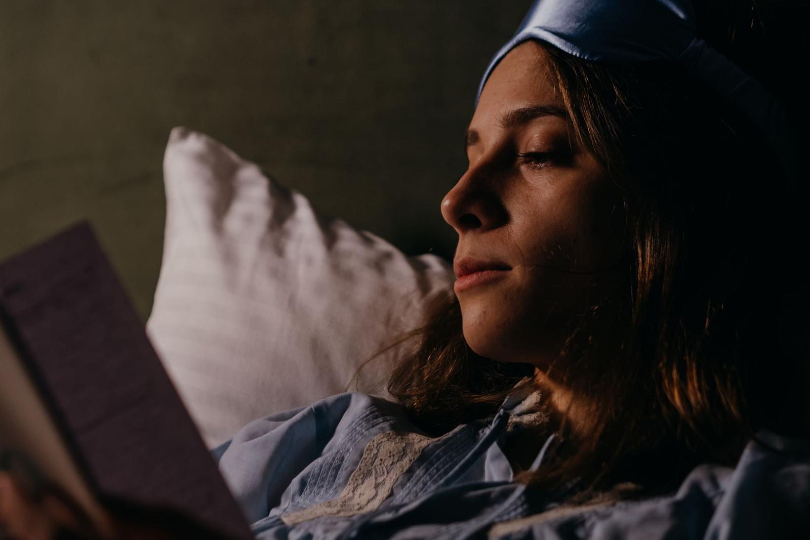 Close Up Photo of Woman Reading Book Before Going to Sleep
